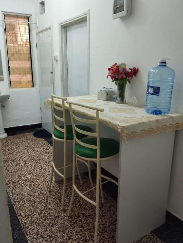 a kitchen with a table with two chairs and a bottle of water at Mombasa Comfort House, Old Town in Mombasa