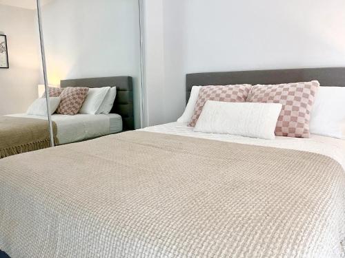 a bedroom with two beds and a mirror at Luxury Condo on Bay Street in Toronto