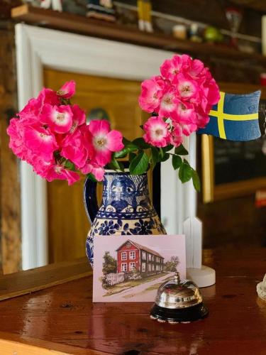 a blue and white vase with pink flowers on a table at Kristianopel Gästgifveri in Karlskrona