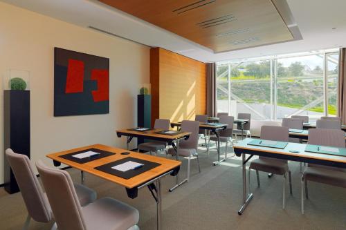 a conference room with tables and chairs and a large window at Sheraton Annaba Hotel in Annaba