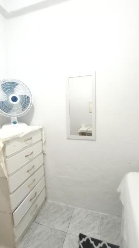 a white bathroom with a white dresser and a mirror at Casa quarto dormitório estudantil em salobrinho para uescquianos in Ilhéus