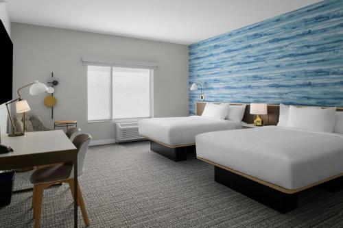 a hotel room with two beds and a desk at TownePlace Suites by Marriott Coeur d'Alene in Coeur d'Alene