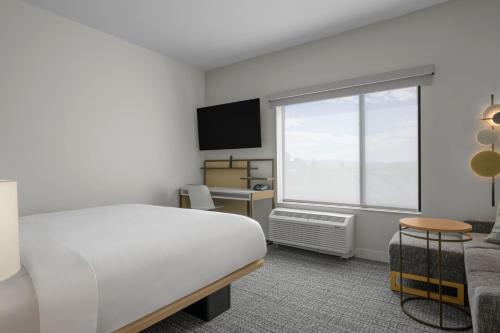 a bedroom with a white bed and a window at TownePlace Suites by Marriott Coeur d'Alene in Coeur d'Alene