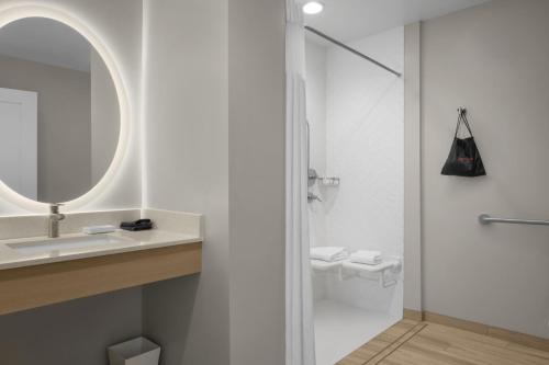 a bathroom with a shower and a sink and a mirror at TownePlace Suites by Marriott Coeur d'Alene in Coeur d'Alene