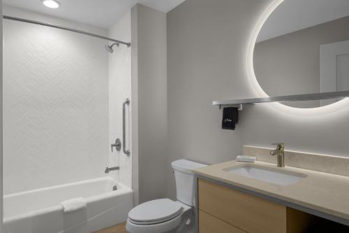 a bathroom with a sink and a toilet and a mirror at TownePlace Suites by Marriott Coeur d'Alene in Coeur d'Alene