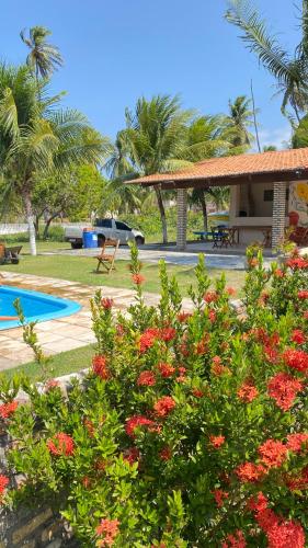 a resort with a garden and a swimming pool at Pousada Do Vozinho in Touros