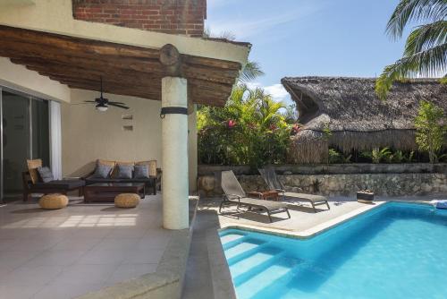 a swimming pool next to a house with a patio at Casa Lucio I Puerto Aventuras I Private Pool in Puerto Aventuras