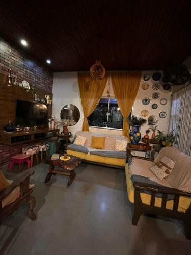 a living room with a couch and a tv at Casa da Joci in Bonito