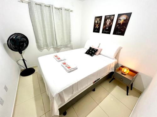 a small white room with a bed in it at Casa Aconchegante 11 pessoas próximo ao aeroporto in Lauro de Freitas