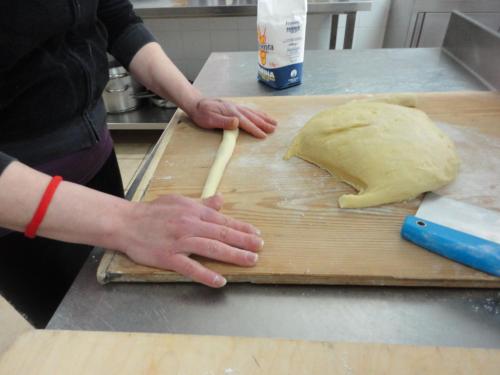 a person kneading a piece of dough on a cutting board at Tenuta Montelaura in Forino