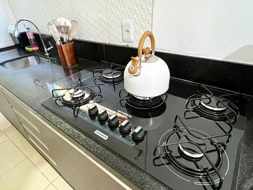 a kitchen stove with a tea kettle on top of it at Casa Aconchegante 11 pessoas próximo ao aeroporto in Lauro de Freitas