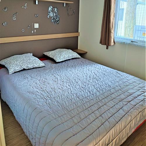 - un lit avec 2 oreillers dans une chambre dans l'établissement Mobil home 2 chambres Saint-Jean-de-Monts, à Saint-Jean-de-Monts