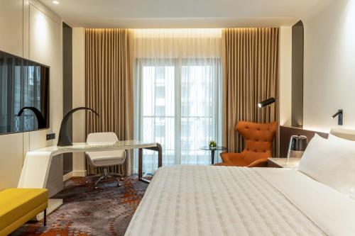 a hotel room with a bed and a desk at Le Royal Méridien Place Vendôme Lusail in Doha