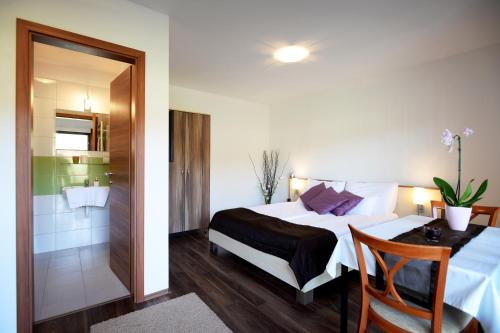 エゲルサロークにあるSzalóki Üdülőházのベッドとバスルーム付きのホテルルームです。