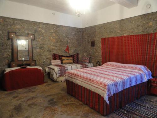 a bedroom with two beds and a mirror at Zeus House in Agios Konstantinos