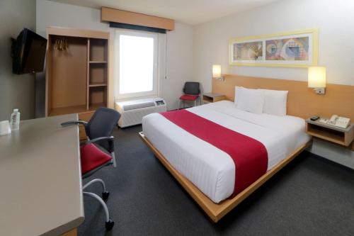 a hotel room with a large bed and a desk at City Express by Marriott Tepotzotlán in Tepotzotlán