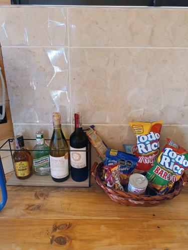 a basket of food and bottles of wine and chips at Cabaña al aire libre en Macheta Cundinamarca - Tiny House - Glamping Caelum in Machetá