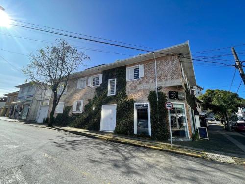 a brick building with ivy on the side of a street at Prédio Histórico na Rio Branco in Caxias do Sul