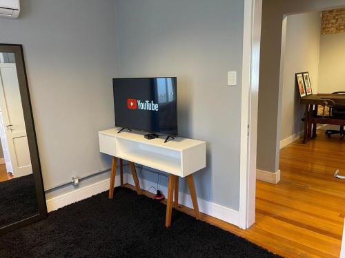 a tv on top of a white table in a room at Prédio Histórico na Rio Branco in Caxias do Sul