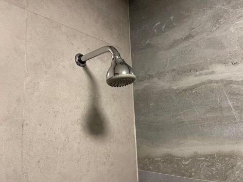 a shower with a light on a wall at Prédio Histórico na Rio Branco in Caxias do Sul