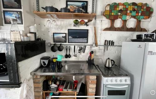 a kitchen with a sink and a refrigerator at Prédio Histórico na Rio Branco in Caxias do Sul