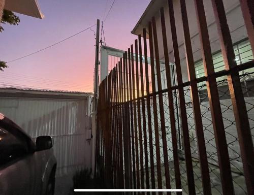 a fence in front of a house with a building at Prédio Histórico na Rio Branco in Caxias do Sul