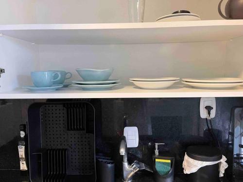 a shelf with bowls and plates on it at Prédio Histórico na Rio Branco in Caxias do Sul