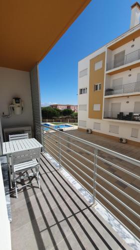 a balcony with a picnic table and a building at Condomínio do Cabedelo in Figueira da Foz