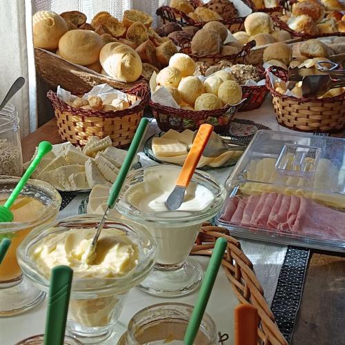 un tavolo imbandito con diversi tipi di dessert e pasticcini di Casa de Barro - Chalés a Santo Antônio do Pinhal