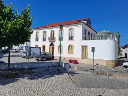 a white building with a car parked in front of it at S Pedro Serta in Sertã