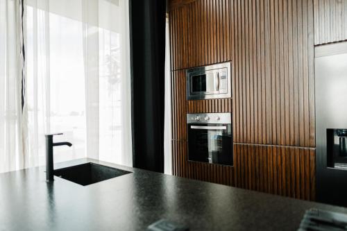 a kitchen with a counter with a microwave and a stove at Loft303 in Aguascalientes