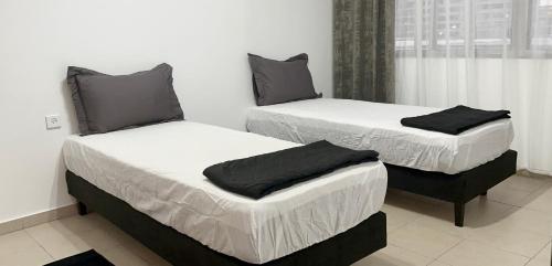 テルアビブにあるStylish Tel Avivの窓のある部屋にツインベッドが2台