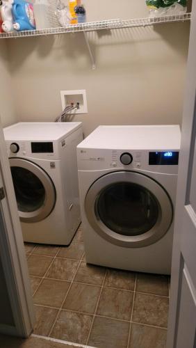two washing machines sitting in a laundry room at The King place, is a ROOM in a PRIVATE HOUSE, close to CTrain and Spruce Meadows Equestrian in Calgary