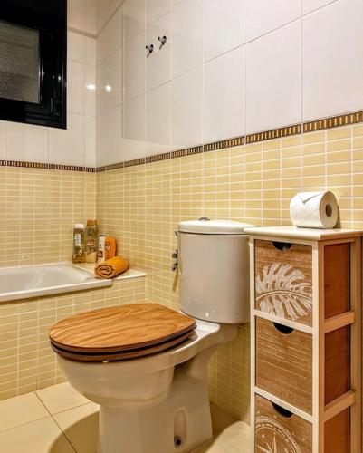 a bathroom with a toilet with a wooden toilet seat at Cabaña Amida in Lajares