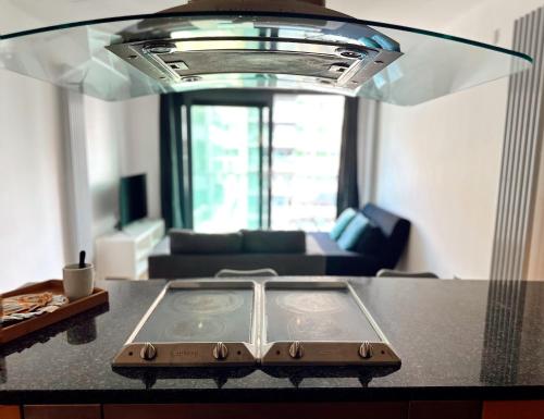 a kitchen with a counter top with a living room at Canary Wharf - Luxury Apartments in London