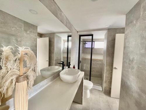 a bathroom with two sinks and a toilet and a tub at Hermoso Apartamento cerca a la playa in Cartagena de Indias