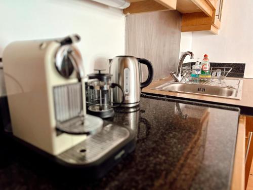 a coffee maker sitting on a kitchen counter next to a sink at Canary Wharf - Luxury Apartments in London