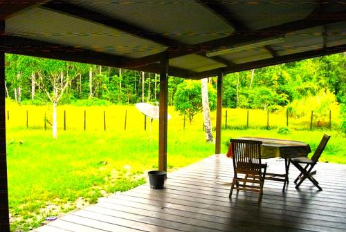 a table and chairs on a porch with an umbrella at Kreyolita in Saint-Laurent du Maroni