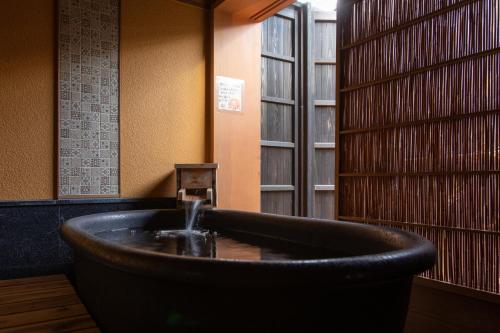 a bath tub in a room with a window at 越中井波町屋旅館古香里庵 in Nanto