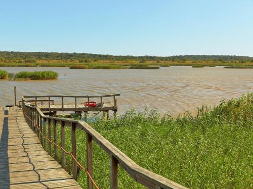 a wooden walkway next to a river with a dock at Perna Perna Lodge St Lucia in St Lucia