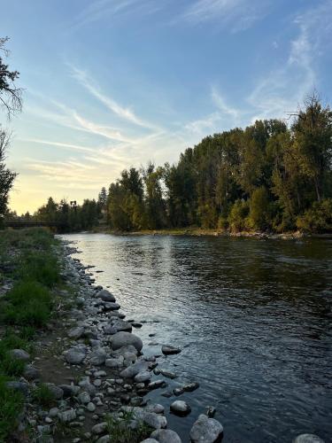 a river with rocks and trees in the background at Methow River Lodge and Cabins in Winthrop