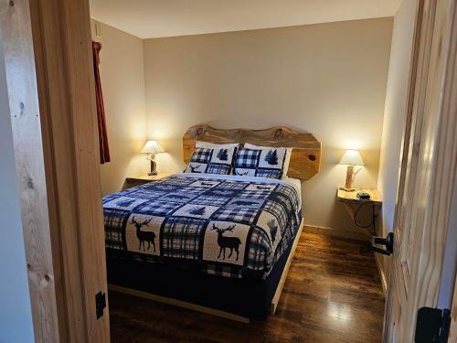 a bedroom with a bed with a quilt with goats on it at Methow River Lodge and Cabins in Winthrop