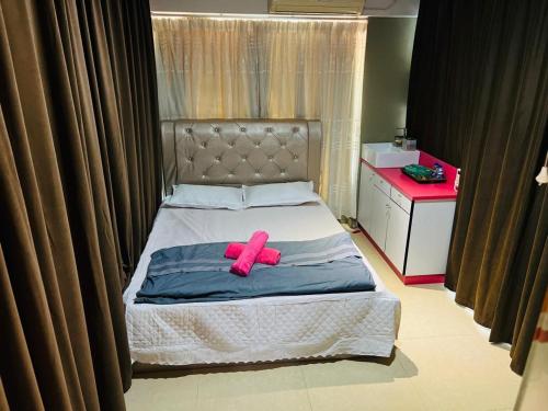 a bed with a pink pair of shoes on it at Family Room with shared Bathroom in Kuala Terengganu