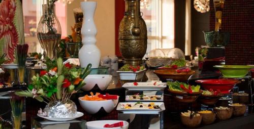 a table filled with plates of food and vases at Executives Hotel - Olaya in Riyadh