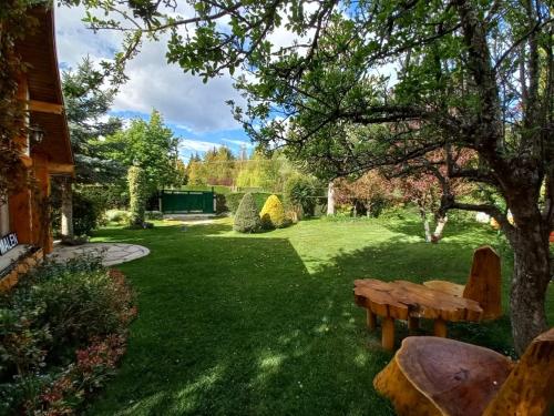 a park with a wooden bench in the grass at Casa Malen Llao Llao in San Carlos de Bariloche