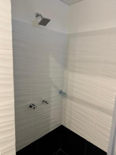 a white shower with two faucets in a bathroom at Dreams hostel in Neiva