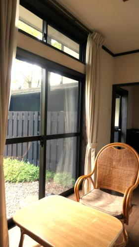 a table and a chair in front of a window at 白水温泉竹の倉山荘 in Minami Aso