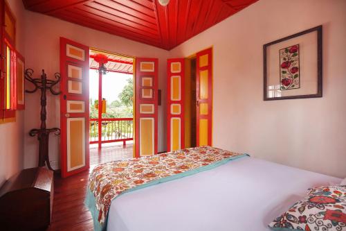 ein Schlafzimmer mit einem Bett in einem Zimmer mit einem Fenster in der Unterkunft Coronel's Peak Coffee House in Salento