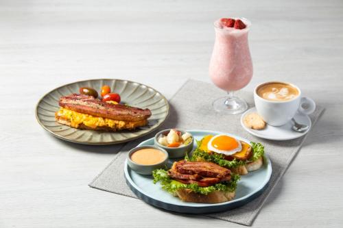 a table with two plates of food and a drink at Chiang Mai Marriott Hotel in Chiang Mai