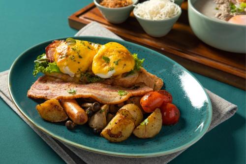 a blue plate of food with an egg and potatoes at Chiang Mai Marriott Hotel in Chiang Mai